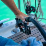 A man holds a petrole pistol and pours gasoline into a yacht on gas petrol station near sea for ship